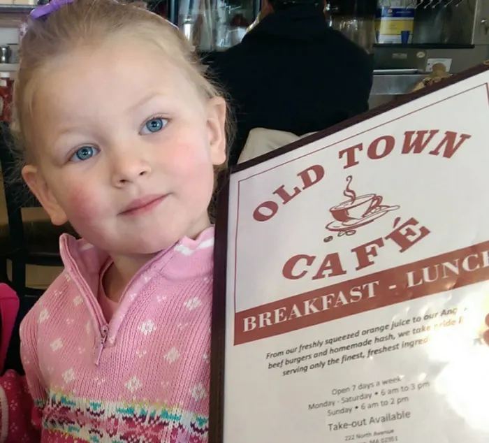 Young guest holding an Old Town Cafe menu